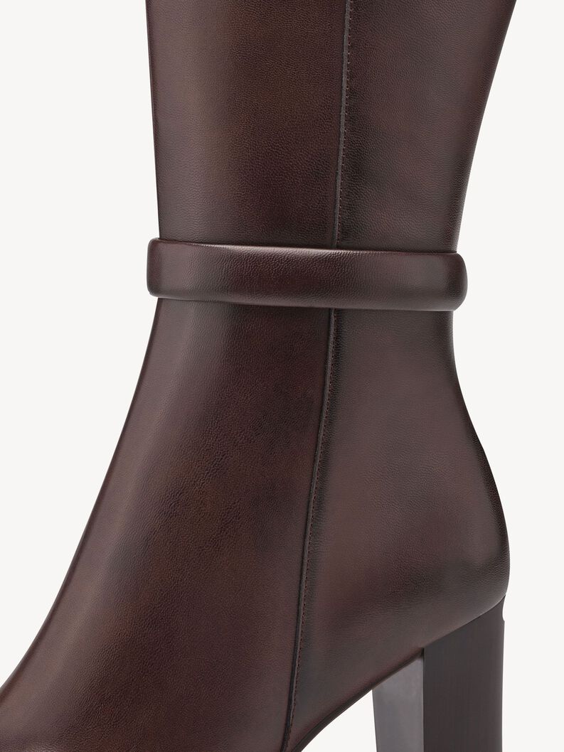 Close-up of brown leather women's boot with decorative ankle strap